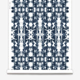 Partially unrolled wallpaper yardage in a painterly ikat print in navy and white.