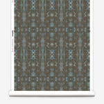 Partially unrolled wallpaper yardage in a painterly ikat print in turquoise and brown.