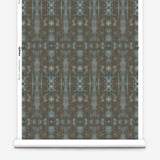 Partially unrolled wallpaper yardage in a painterly ikat print in turquoise and brown.