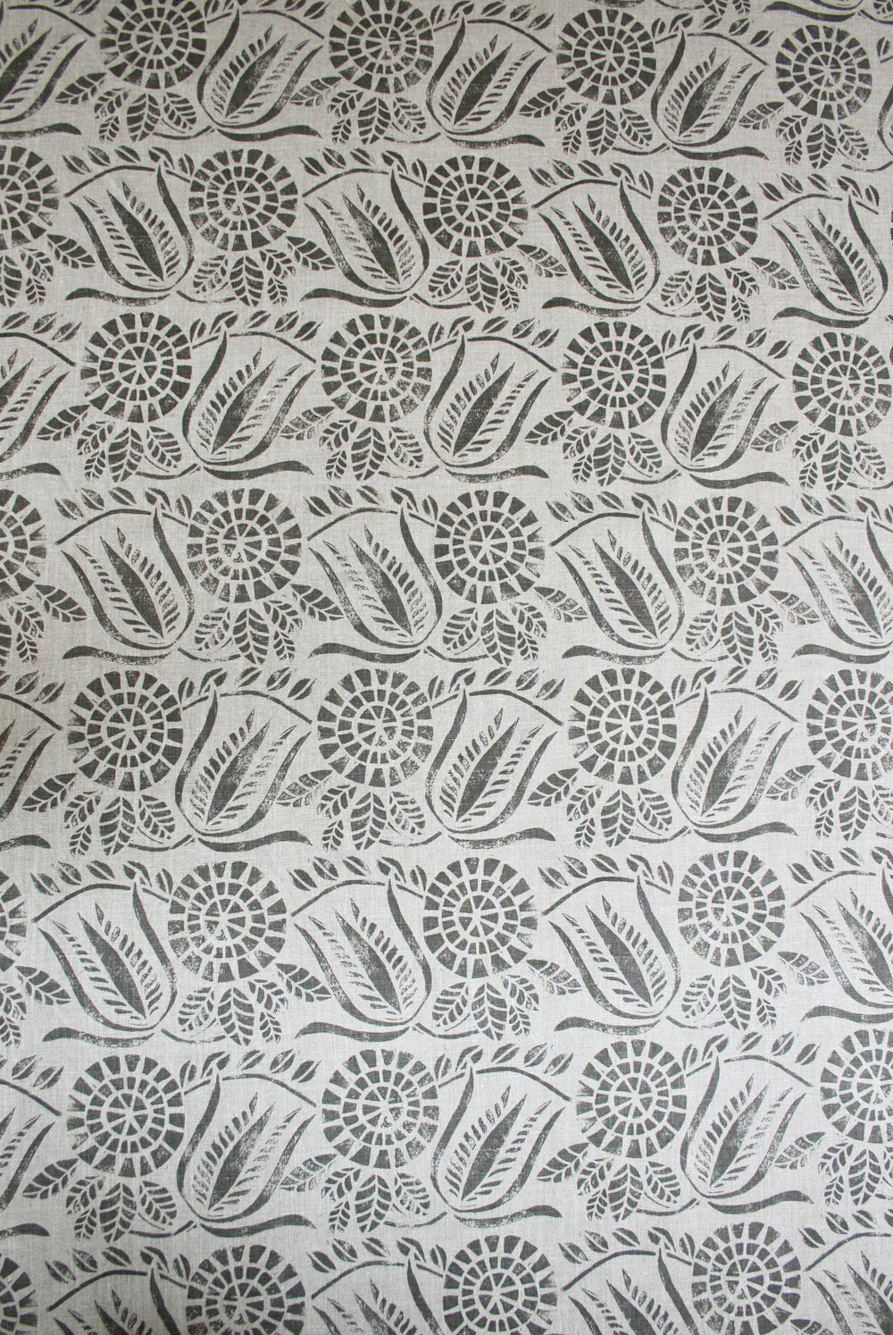 Detail of fabric in a dense floral print in gray on a white field.