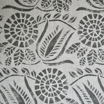 Close-up of fabric in a dense floral print in gray on a white field.