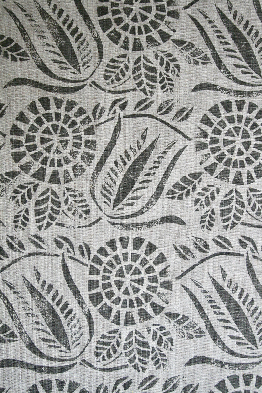 Close-up of fabric in a dense floral print in gray on a white field.