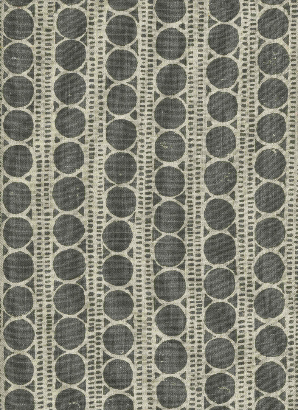 Detail of fabric in a circle and stripe print in cream on a gray field.