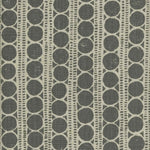 Detail of fabric in a circle and stripe print in cream on a gray field.