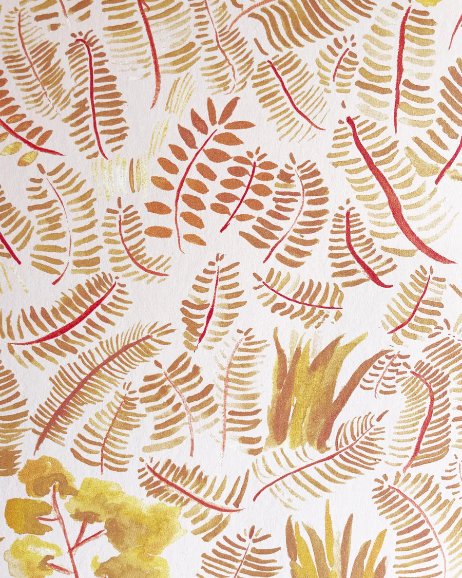 Detail of wallpaper in a playful leaf print in shades of yellow and orange on a white field.