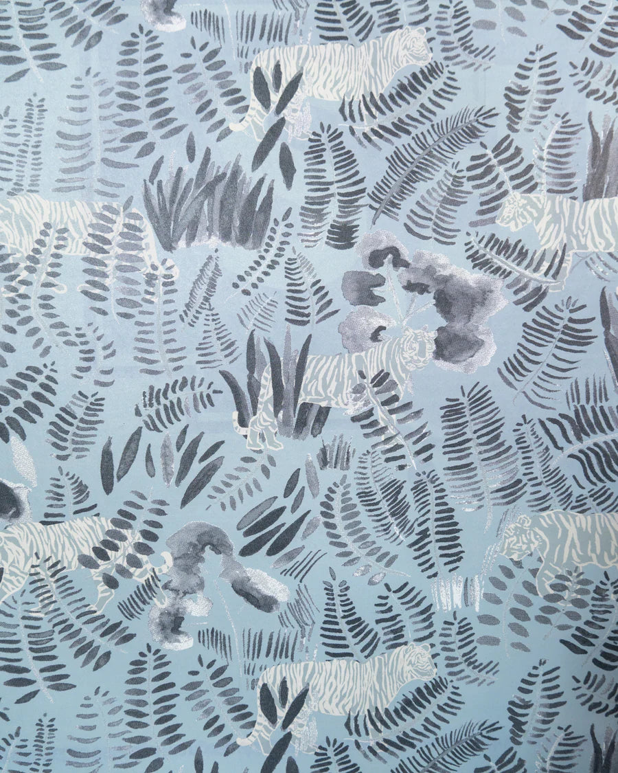 Detail of wallpaper in a playful tiger and leaf print in shades of cream and gray on a light blue field.