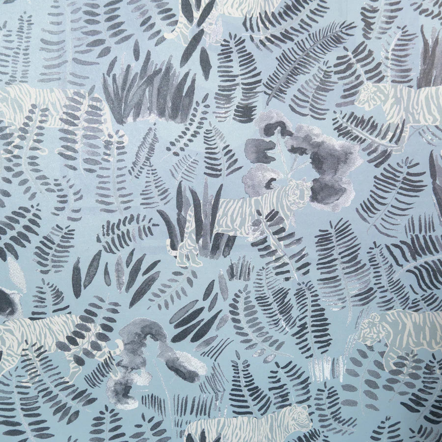 Detail of wallpaper in a playful tiger and leaf print in shades of cream and gray on a light blue field.