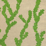 Detail of fabric in a dimensional embroidered botanical print in green on a tan field.