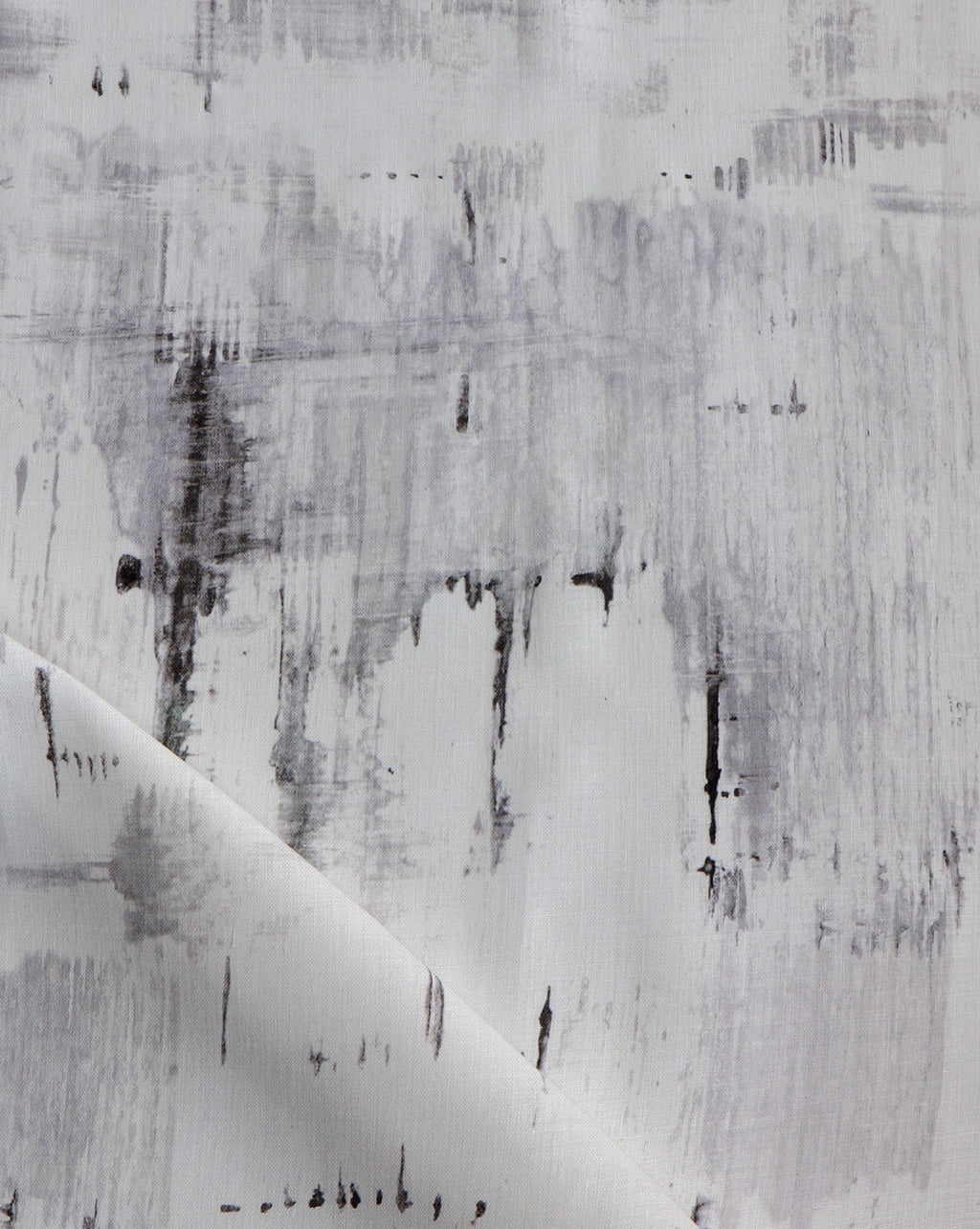 Detail of fabric in an abstract paint blot print in black and gray on a white field.