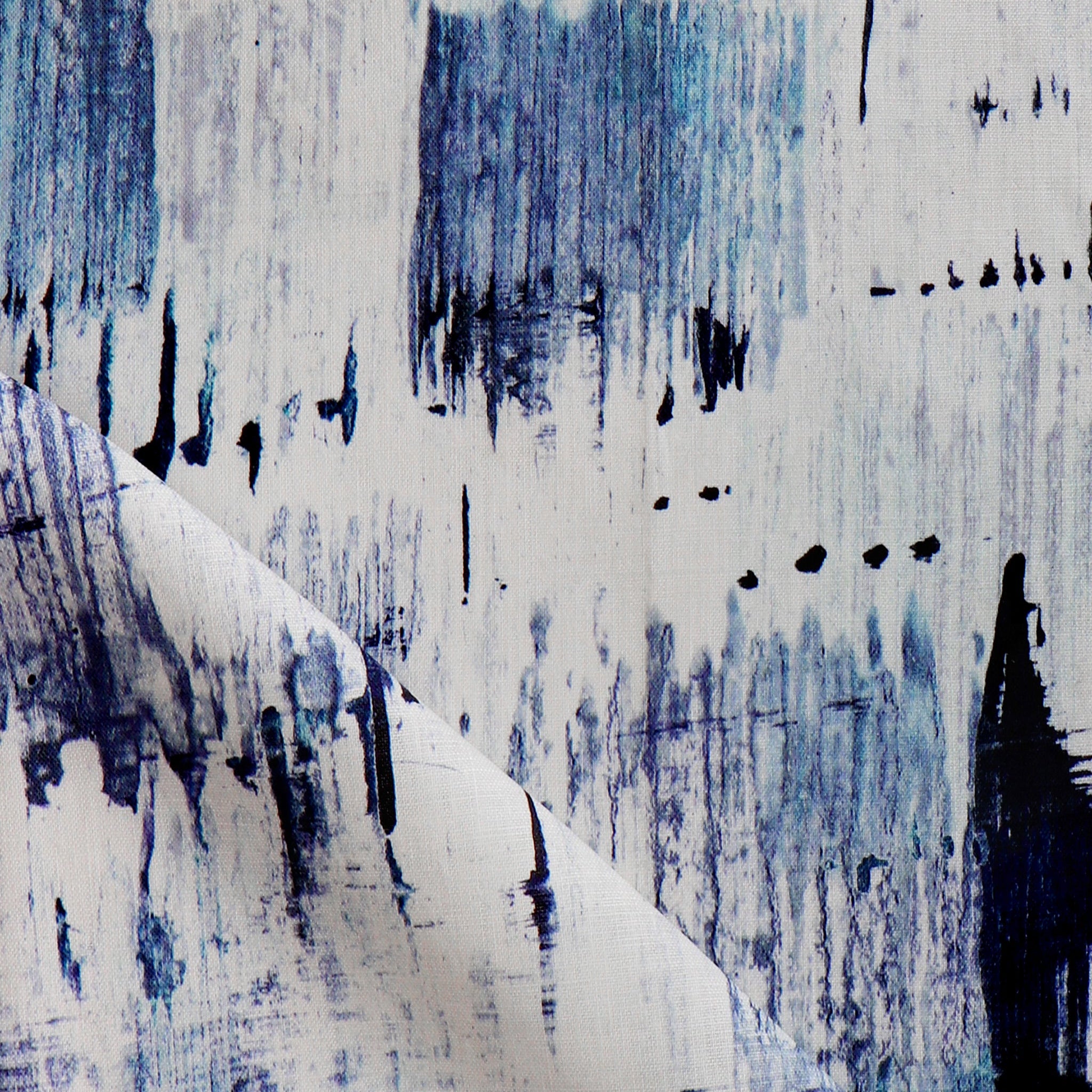 Detail of fabric in an abstract paint blot print in blue on a white field.