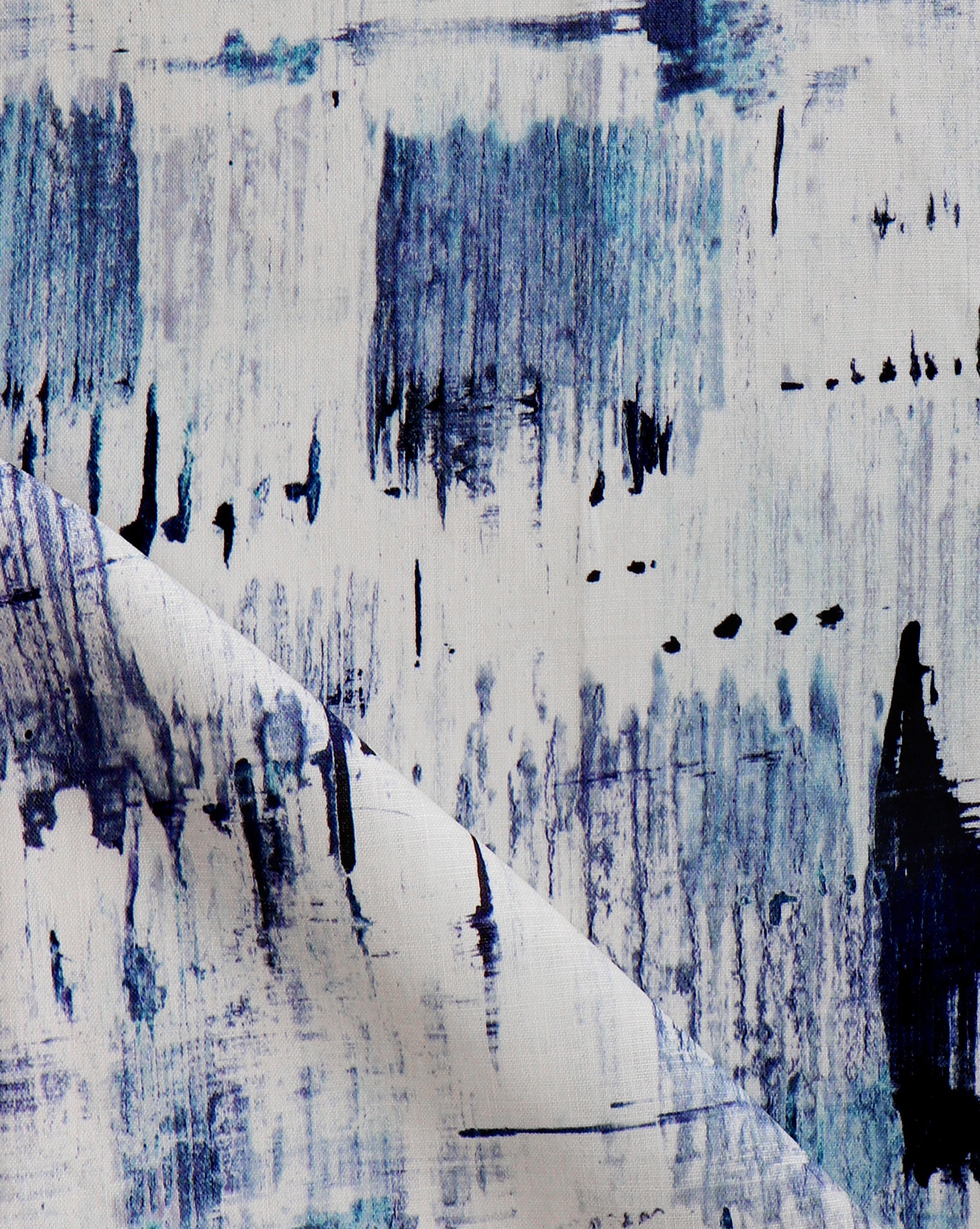 Detail of fabric in an abstract paint blot print in blue on a white field.