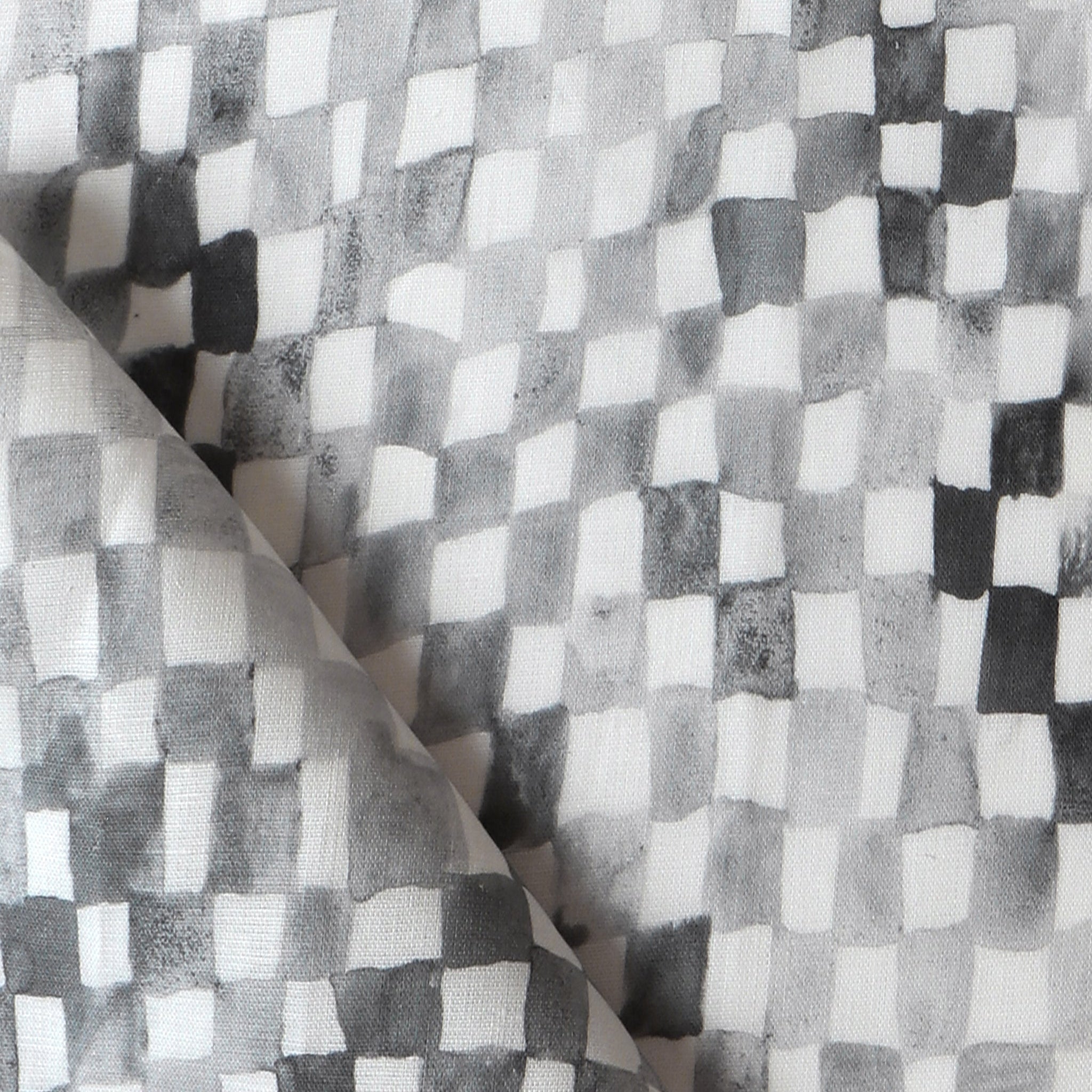 Detail of fabric in a painterly check pattern in shades of gray and charcoal on a white field.