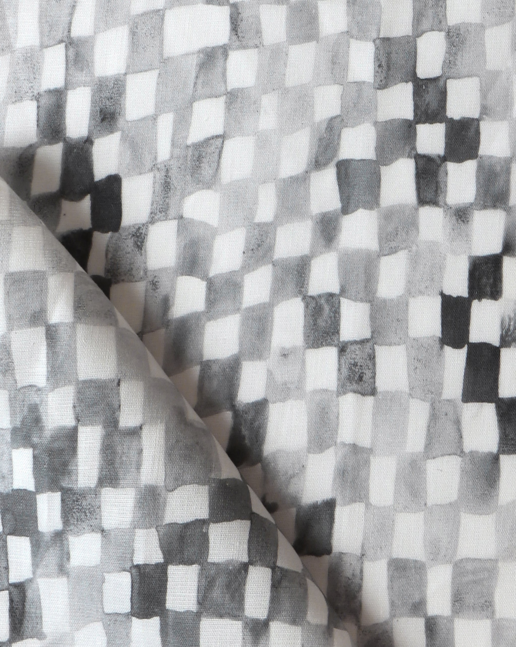 Detail of fabric in a painterly check pattern in shades of gray and charcoal on a white field.