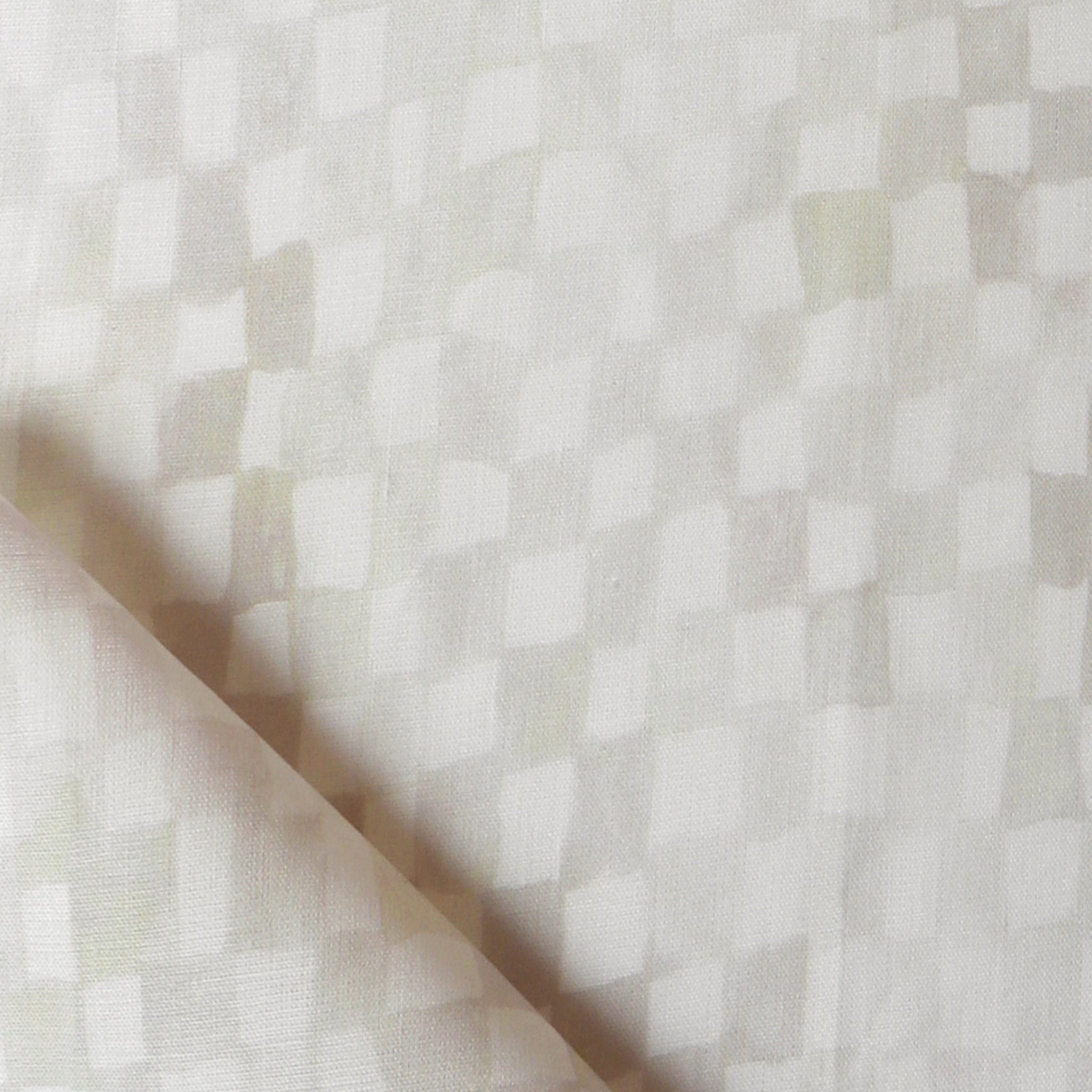 Detail of fabric in a painterly check pattern in cream on a white field.