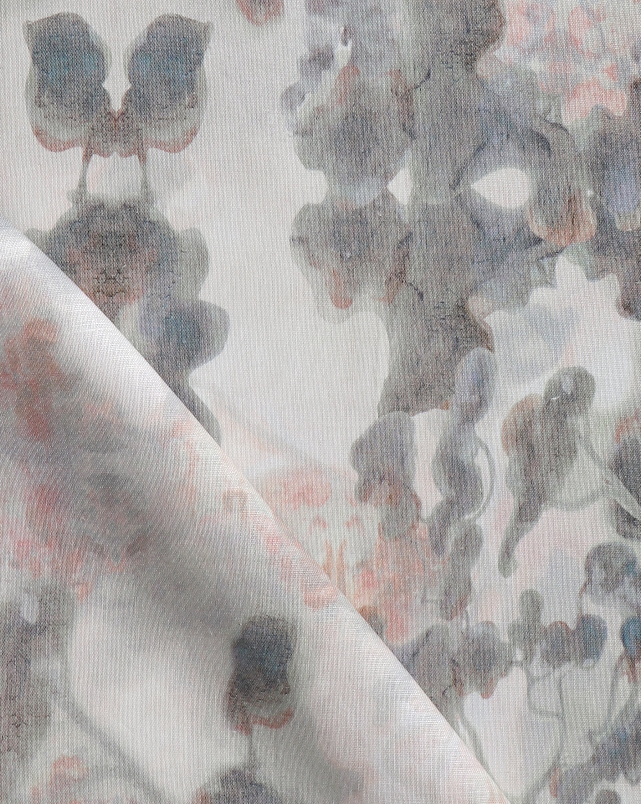 Detail of fabric in an abstract botanical print in shades of pink and gray on a greige field.