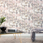 A modernist living tableau with a wall papered in an abstract botanical print in gray, peach, tan and white.