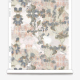 Partially unrolled wallpaper yardage in an abstract botanical print in gray, peach, tan and white.