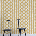 Two minimalist black chairs stand in front of a wall papered in a playful curvy stripe print in white, gray and mustard.