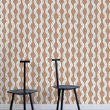 Two minimalist black chairs stand in front of a wall papered in a playful curvy stripe print in white, blue and brown.