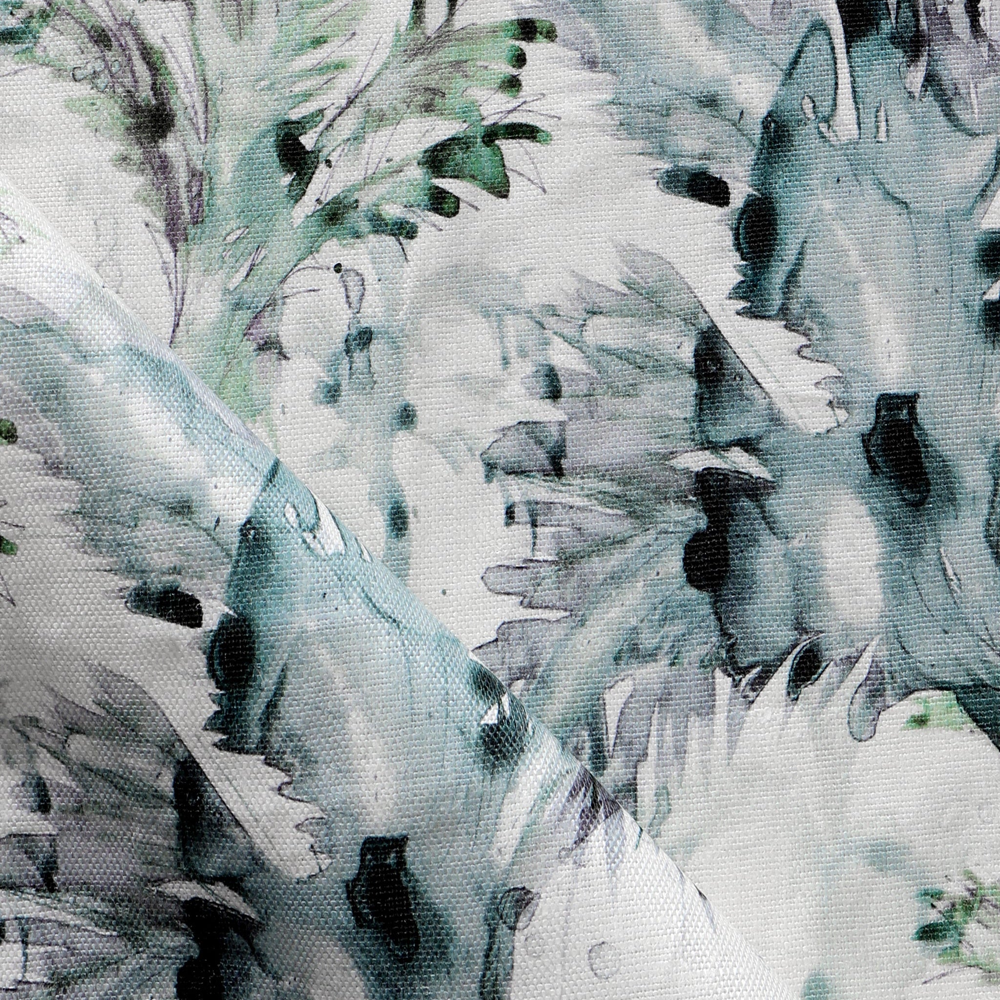 Detail of fabric in a painterly palm leaf print in shades of green, turquoise and gray on a cream field.