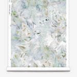 Partially unrolled wallpaper yardage in an abstract painted print in shades of blue, green, yellow and white.