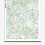 Partially unrolled wallpaper yardage in an abstract painted print in shades of green, yellow and white.