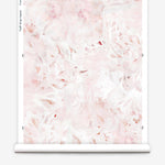 Partially unrolled wallpaper yardage in an abstract painted print in shades of pink, red and white.