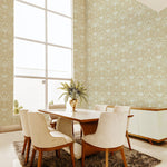 A modernist dining room with a tall window and walls papered in a floral damask print in cream and tan.