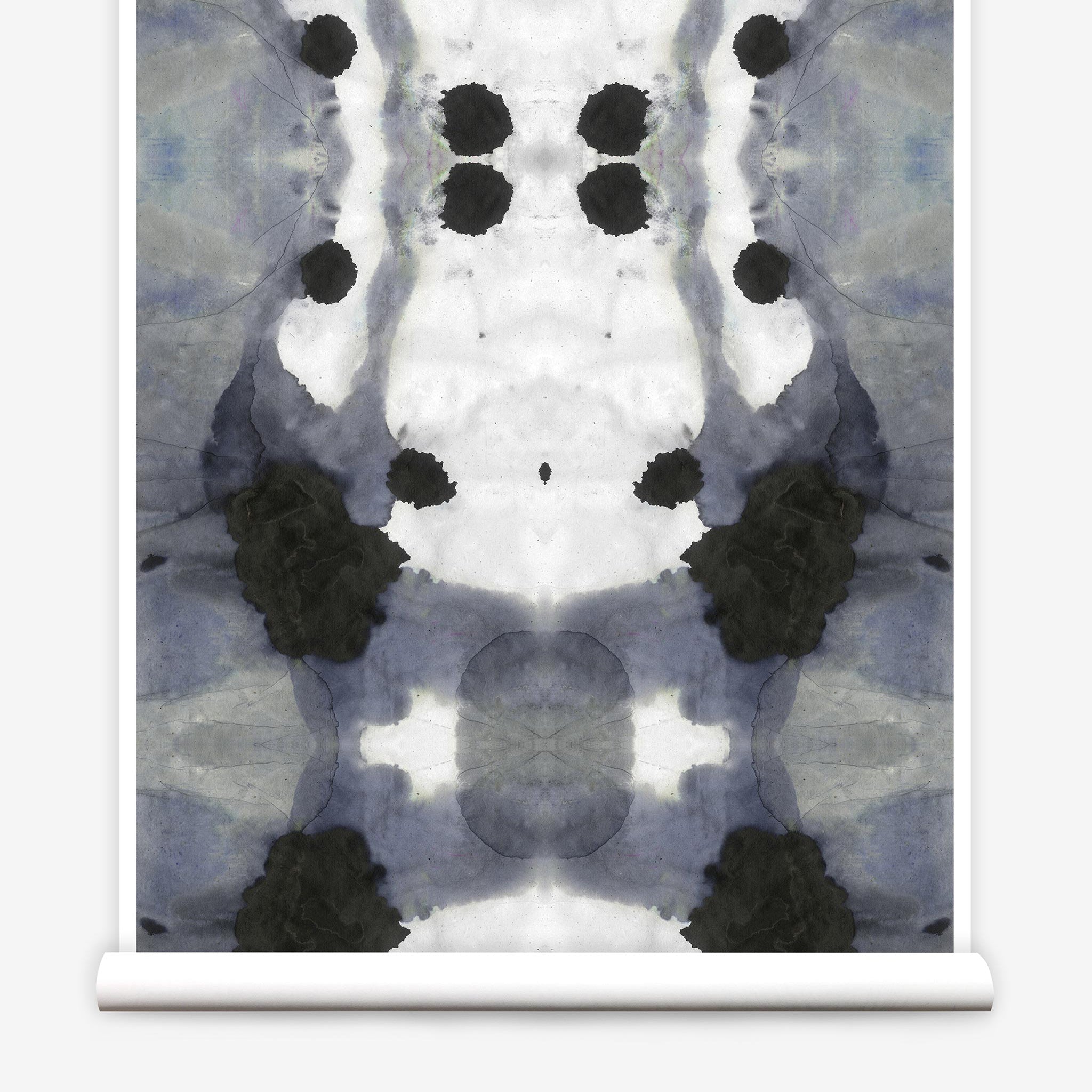 Partially unrolled wallpaper yardage in an abstract ink blot print in charcoal, gray and white.