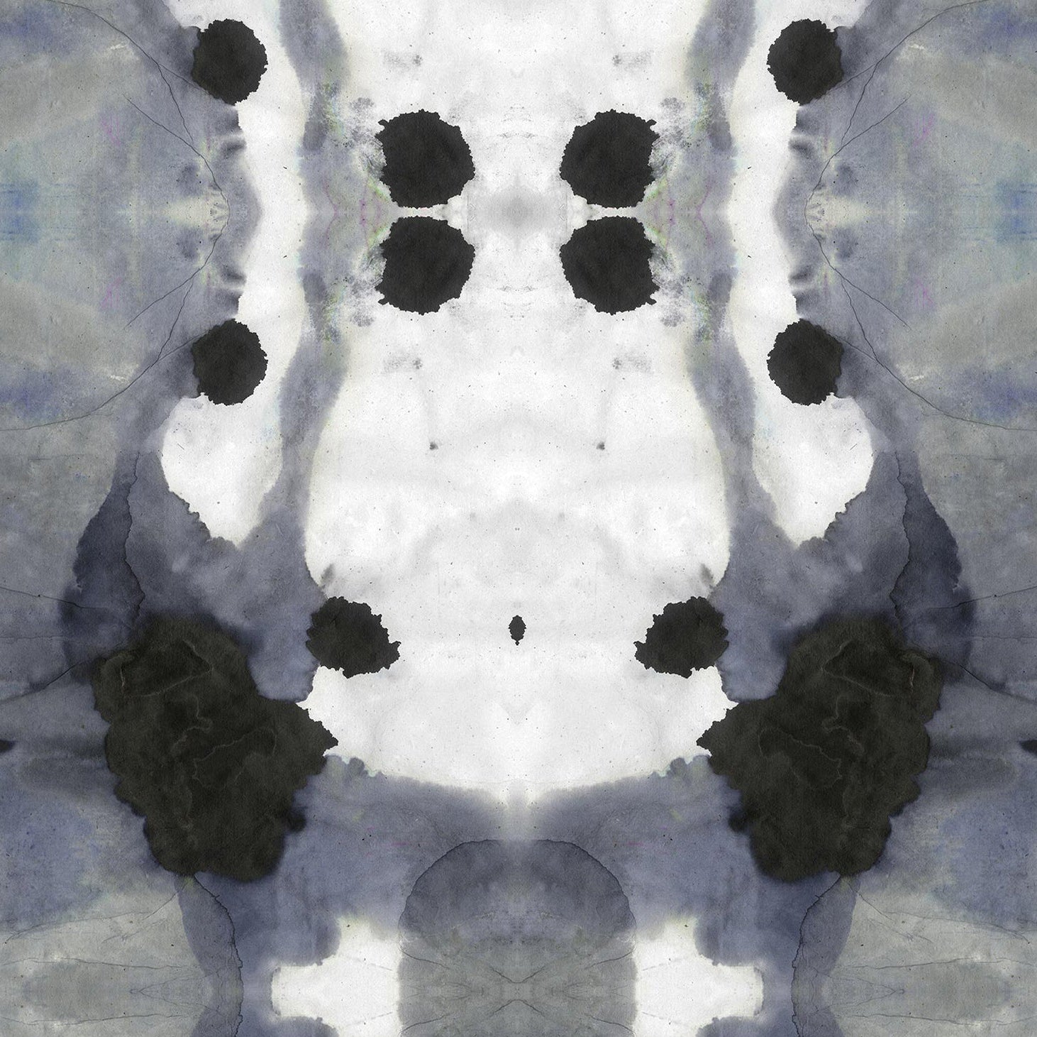 Detail of wallpaper in an abstract ink blot print in shades of charcoal and gray on a white field.