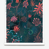 Partially unrolled wallpaper yardage in a playful leaf and snake print in pink, blue, green and dark turquoise.