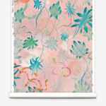 Partially unrolled wallpaper yardage in a playful leaf and snake print in turquoise, pink, green and coral.