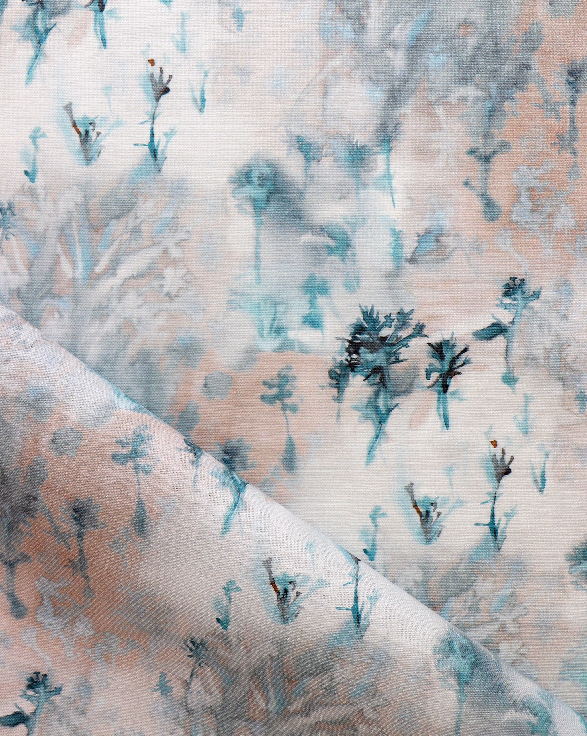 Detail of fabric in a painterly tree print in light turquoise and gray on a coral field.