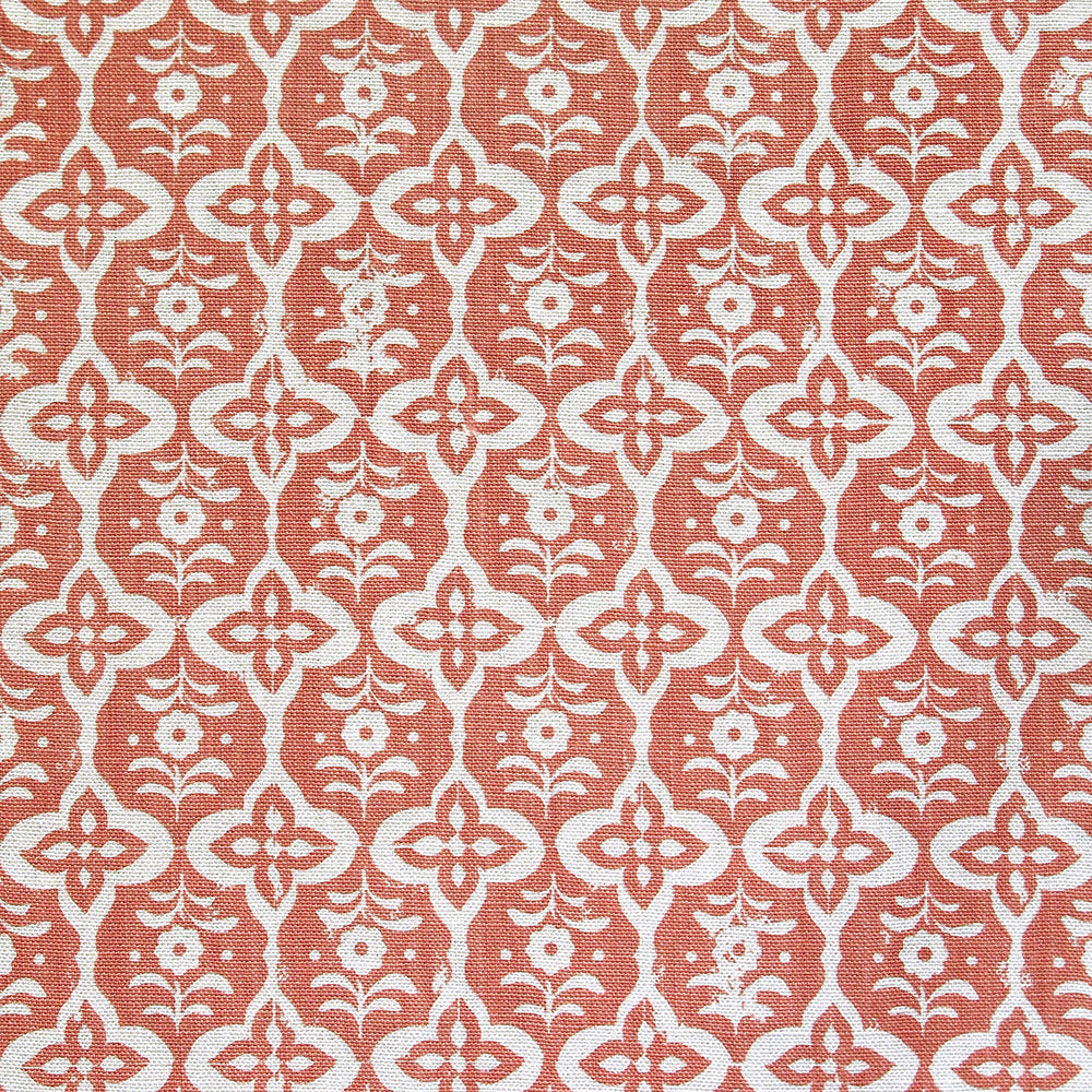 Detail of fabric in a floral grid print in cream on a coral field.