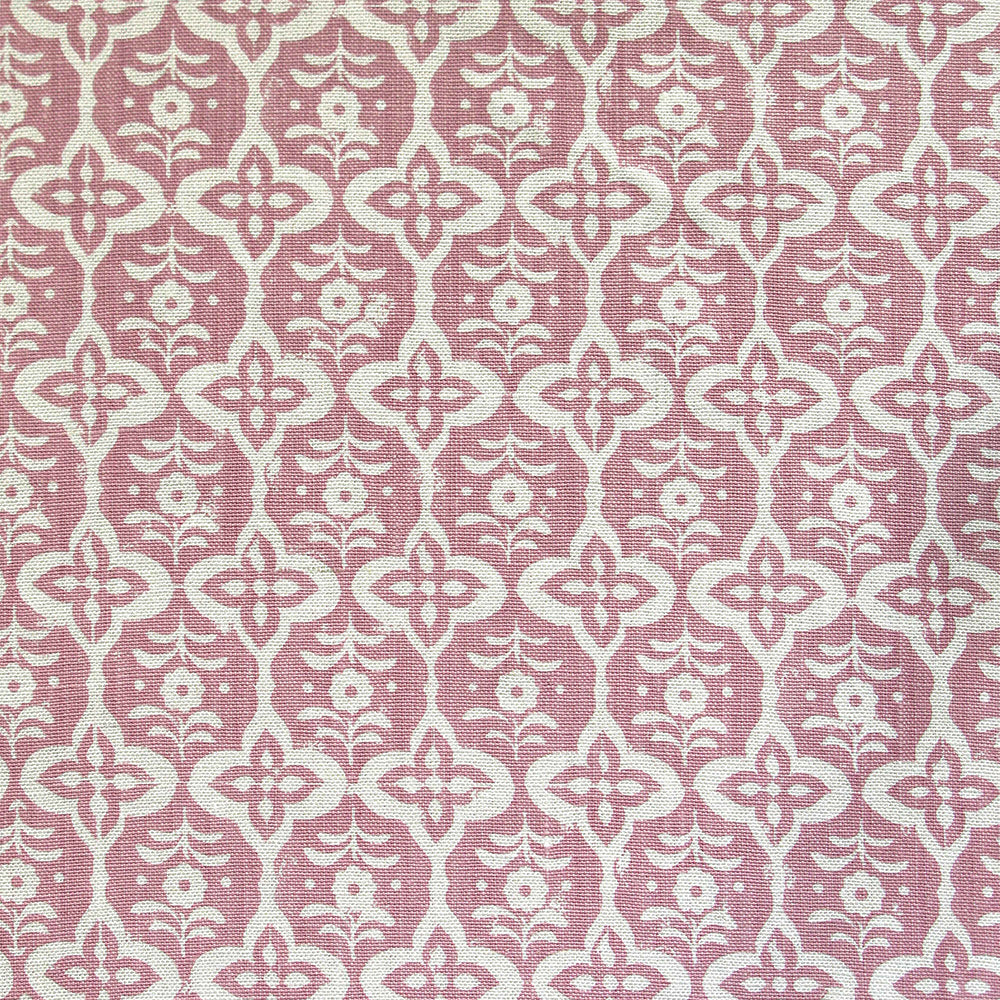 Detail of fabric in a floral grid print in cream on a pink field.