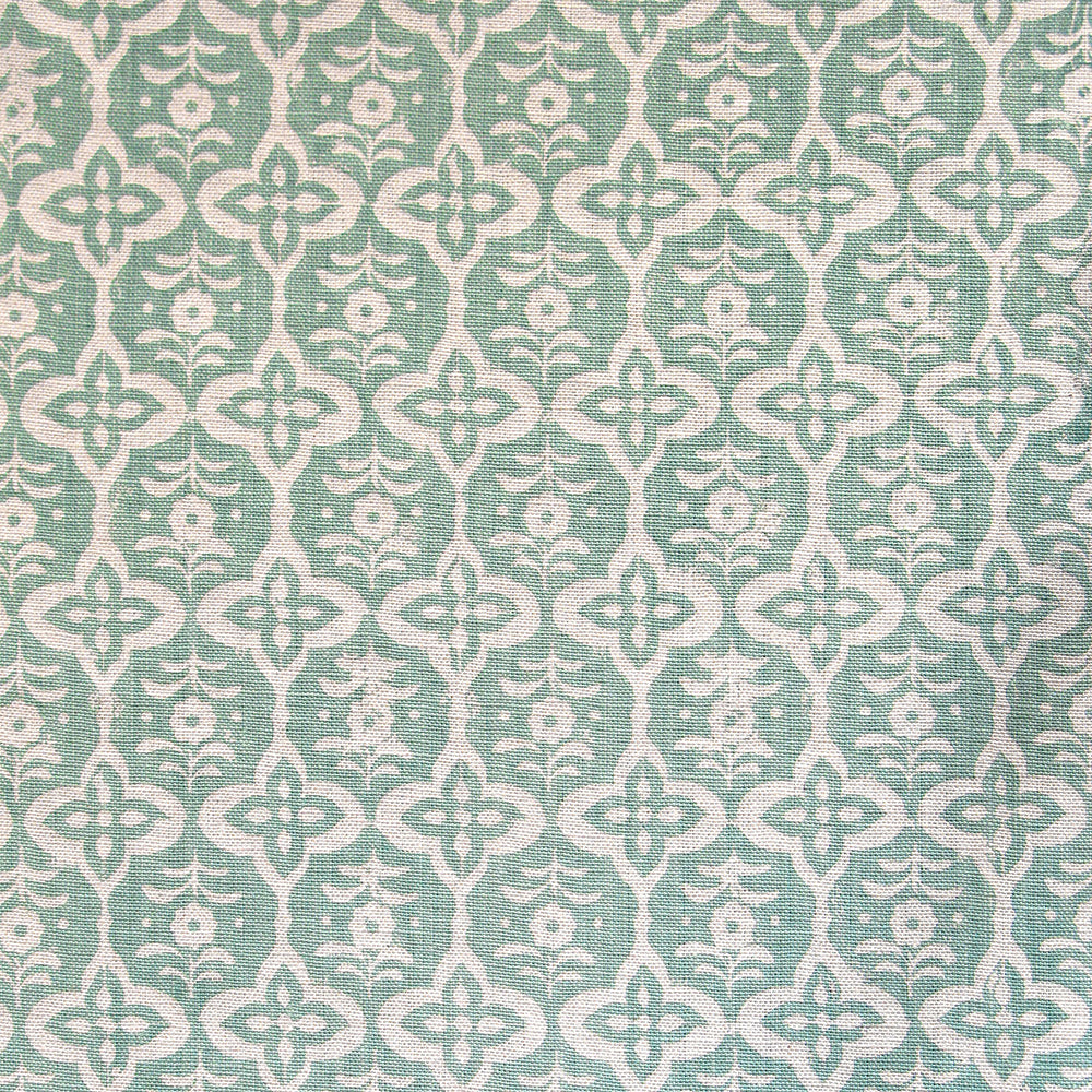 Detail of fabric in a floral grid print in cream on a light green field.