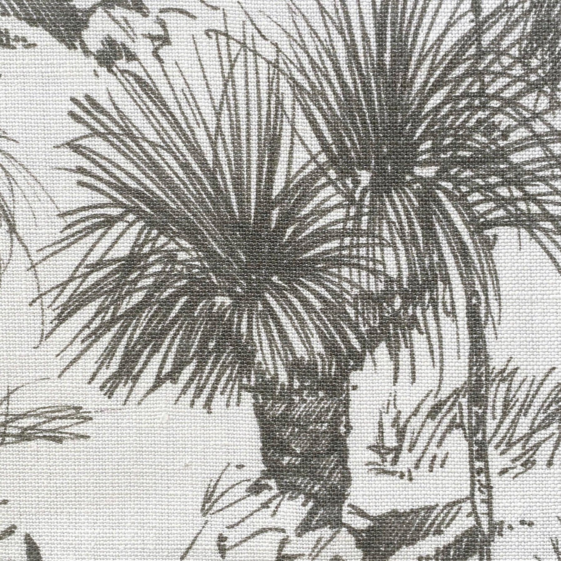 Close-up of fabric in a painterly tree print in gray on a white field.