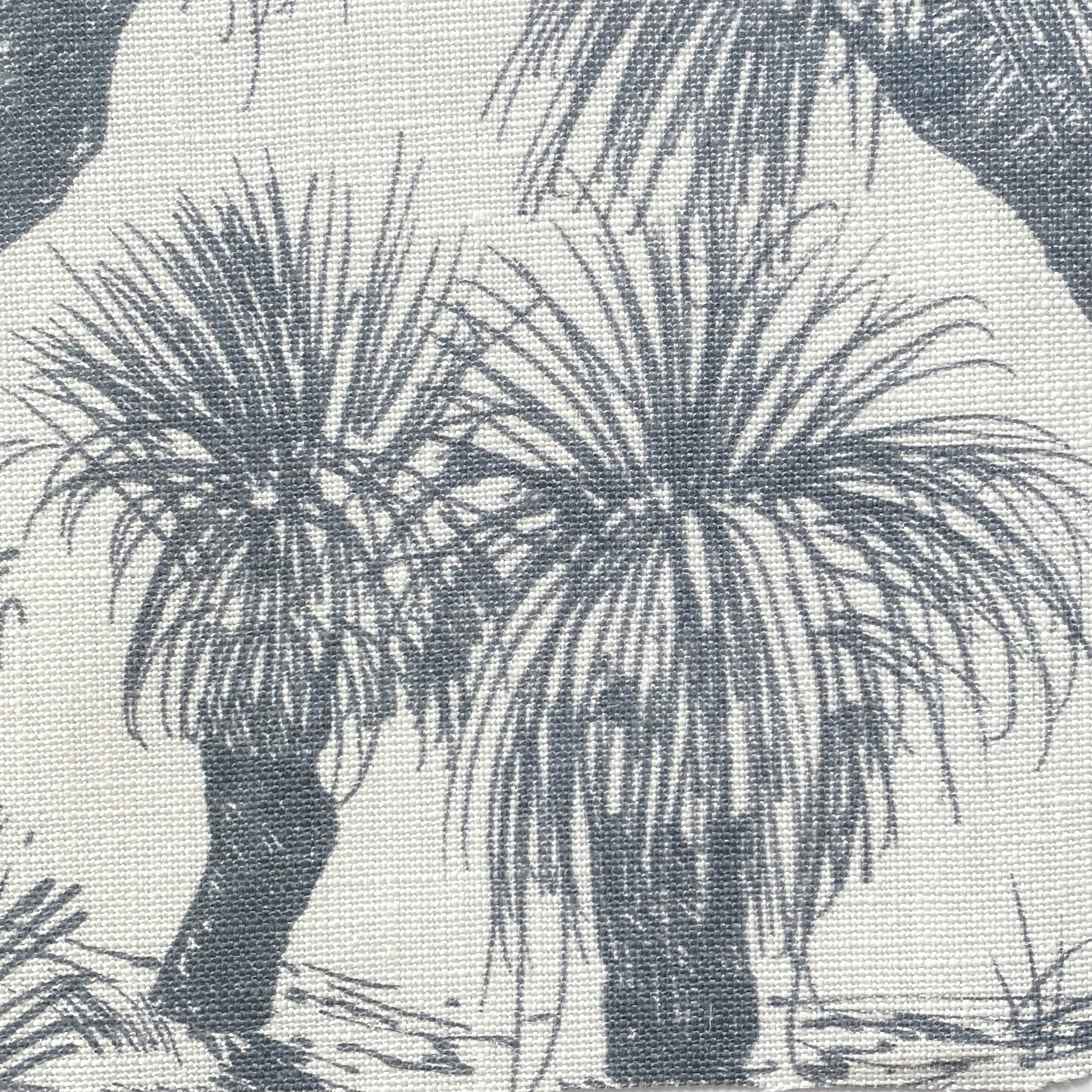 Close-up of fabric in a painterly tree print in navy on a white field.