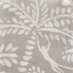 Close-up of fabric in a playful palm tree and monkey print in white on a light gray field.