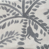 Close-up of fabric in a playful palm tree and monkey print in navy on a cream field.