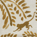 Close-up of fabric in a playful palm tree and monkey print in gold on a cream field.