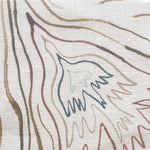 Close-up of fabric in a playful abstract sun print in brown and blue on a white field.