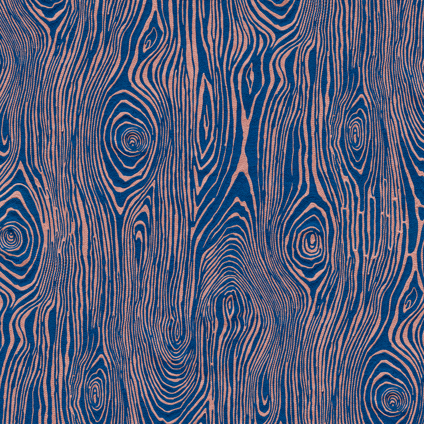 Detail of wallpaper in a textural wood grain print in pink on a blue field.