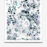 Partially unrolled wallpaper yardage in an abstract paint blotch print in black, gray, blue, green and white.