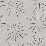 Detail of wallpaper in a playful firework print in black on a greige field.