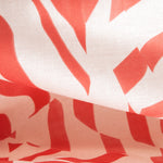 Draped fabric yardage in a playful broken stripe print in coral on a cream field.