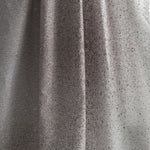 Draped fabric yardage in an abstract ombré paint splatter print in shades of gray and white.