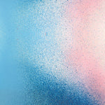 Detail of fabric in an abstract ombré paint splatter print in shades of blue, white, pink and navy.