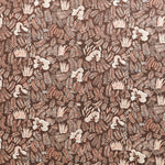 Detail of fabric in a painterly botanical print in shades of cream and pink on a brown field.