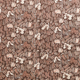 Detail of fabric in a painterly botanical print in shades of cream and pink on a brown field.